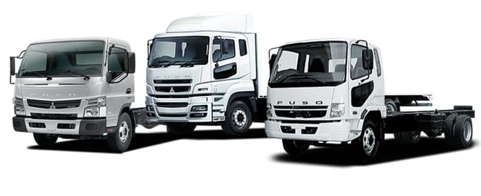 A fleet of various large Japanese trucks